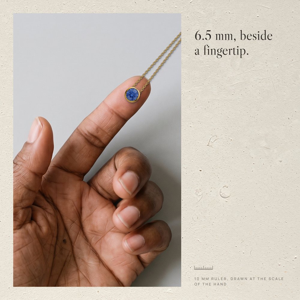 Fingertip with the Corund pendant and a 10 mm ruler at the same scale